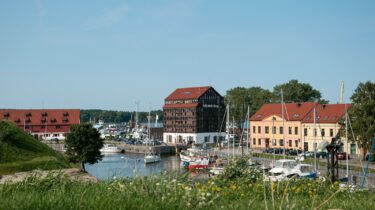 red and white houses near body of water during daytime