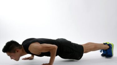 Young man in athletic wear doing push-ups, showcasing strength and fitness.